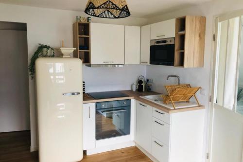 uma cozinha com armários brancos e um frigorífico em Quiet apartment with sea view em Villers-sur-Mer