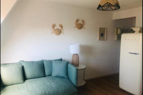 - un salon avec un canapé et une table avec une lampe dans l'établissement Quiet apartment with sea view, à Villers-sur-Mer