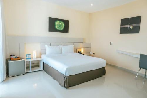 um quarto com uma grande cama branca e uma secretária em Hotel Florida Sinú em Montería
