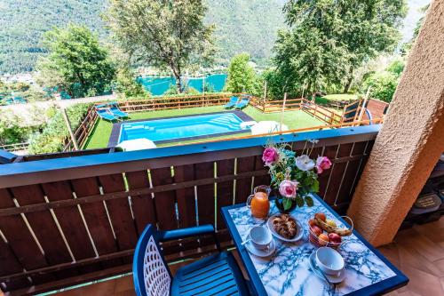 a table on a balcony with a view of a pool at Le Terrazze sul Lago - Ledro House in Pieve Di Ledro