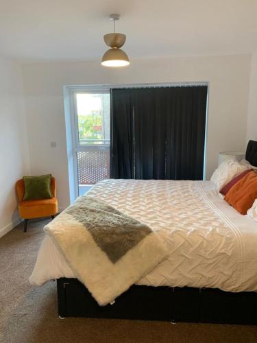 a bedroom with a large bed and a window at Brand New One Bed Luxury Flat No Parties No Events in West Thurrock