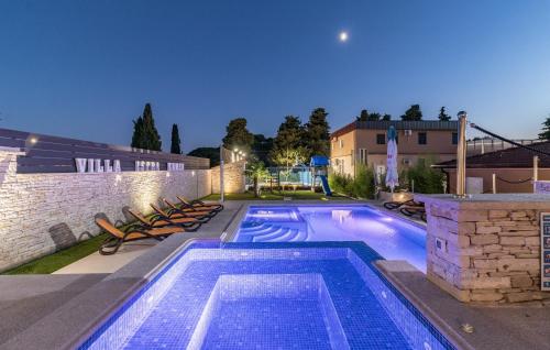 einen Pool mit Stühlen neben einem Gebäude in der Unterkunft Luxurious Villa Istra Kamen in Pula