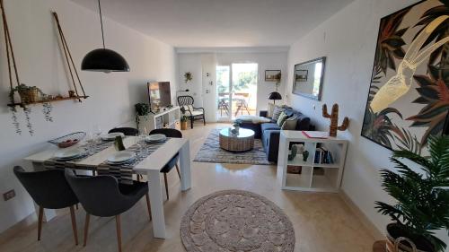 een woonkamer met een tafel en stoelen en een woonkamer bij Sunny holiday Apartment Miraflores in Sitio de Calahonda