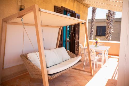 a porch with a swinging bed and a table at Resort Santa Maria Hotel in Birgi Vecchi