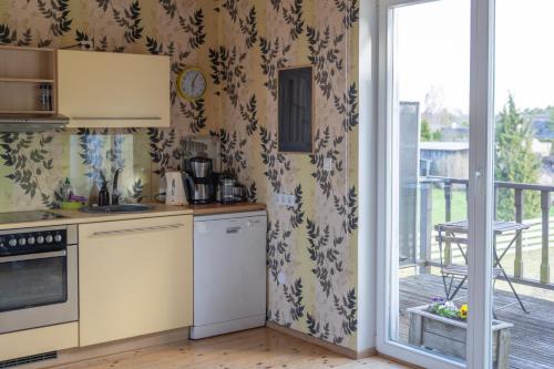a kitchen with a stove top oven next to a balcony at Rannakivi Puhkemaja in Kärdla