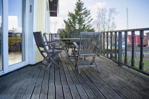 a porch with two chairs and a table on a deck at Rannakivi Puhkemaja in Kärdla