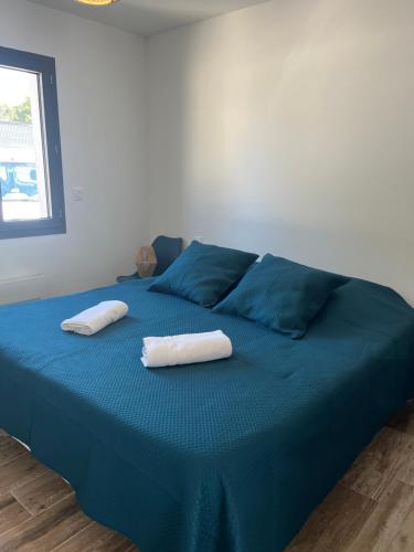 a blue bed with two white towels on it at Les jardins de la Gravière à 5 mn de Lourmarin avec piscine privée in Puyvert