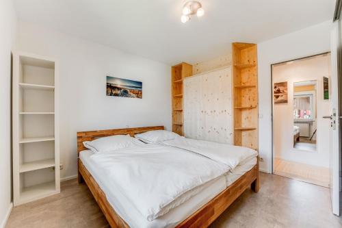 ein Schlafzimmer mit einem großen Bett und Regalen in der Unterkunft TaLu Ferien Wohnung Sonthofen in Sonthofen