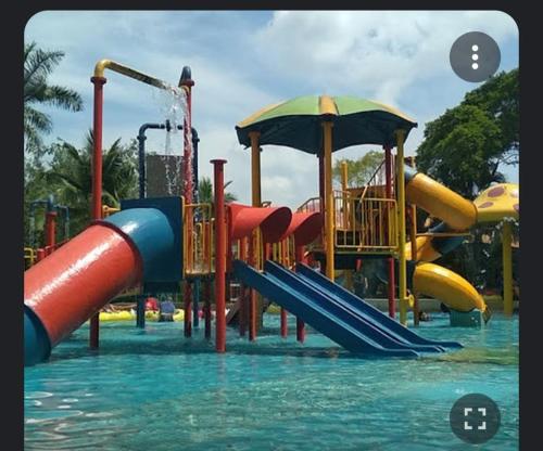 a water park with a slide in the water at Rosnah Homestay in Kampong Ayer Resam
