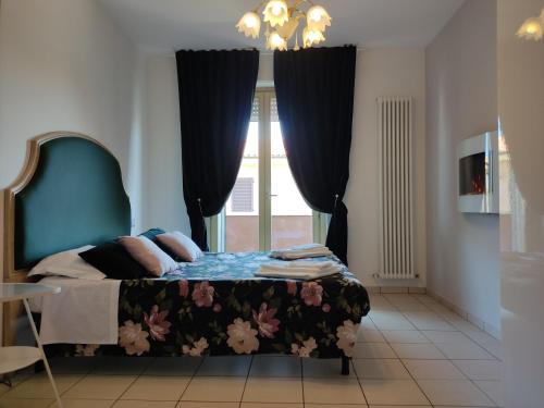a bedroom with a bed with a blue headboard and a window at Lillananna Reload in Porto SantʼElpidio