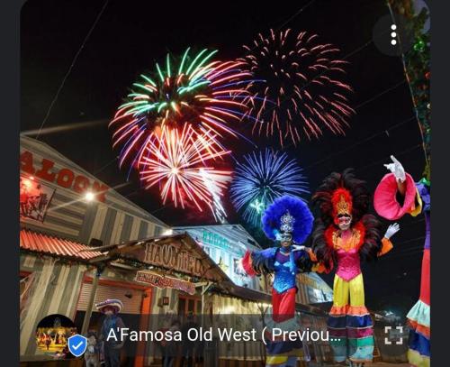 two people in clown costumes standing in front of fireworks at Rosnah Homestay in Kampong Ayer Resam