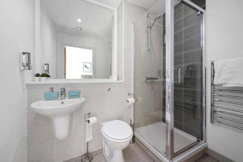 a bathroom with a toilet and a sink and a shower at Stunning 3-Bedroom Flat with Parking in Manchester