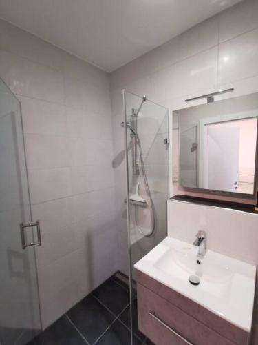 a white bathroom with a sink and a shower at Ferienwohnung Zum Moselfischer in Trittenheim