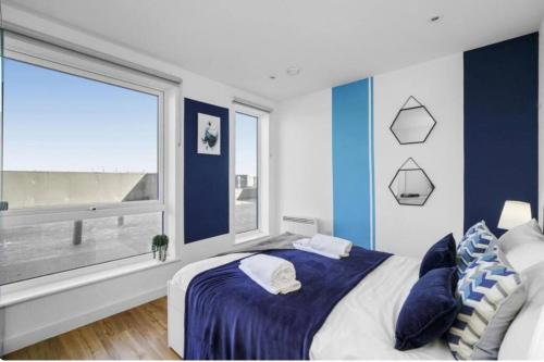 a blue and white bedroom with a large window at Stunning 3-Bedroom Flat with Parking in Manchester