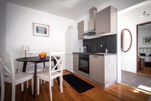 a kitchen and dining room with a table and chairs at Apartman Pergola in Betina