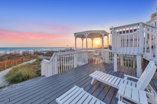a deck with benches and a gazebo on the beach at Sandy Feet Retreat in Panama City Beach