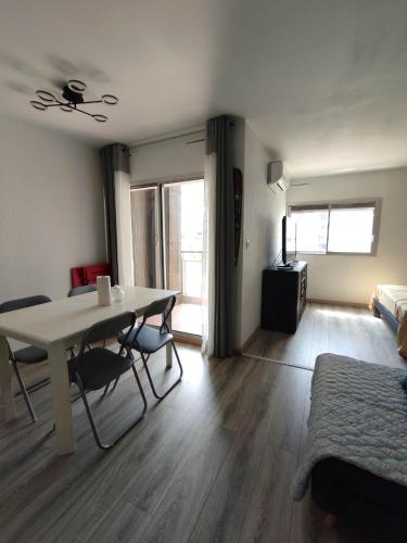 un salon avec une table et des chaises et une chambre dans l'établissement Charmant Studio de 25m² - 30m de la mer - Barcares, au Barcarès