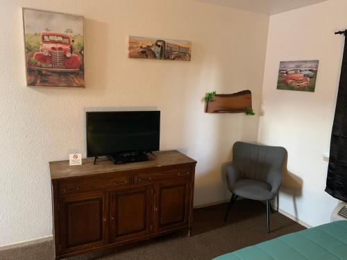a bedroom with a flat screen tv and a chair at Brownsville Motel in Brownsville