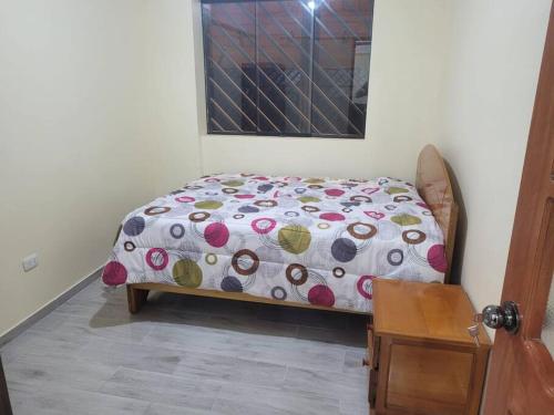 een slaapkamer met een bed met een polka dot-deken bij Apartamento cómodo y tranquilo. Garage gratuito in Cuzco