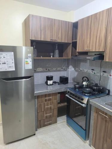 een keuken met een roestvrijstalen koelkast en een fornuis bij Apartamento cómodo y tranquilo. Garage gratuito in Cuzco
