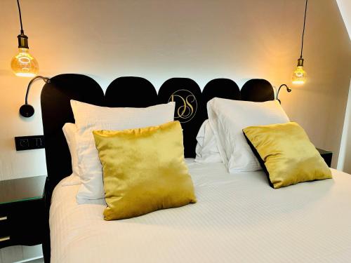 a bed with white pillows and a black headboard at Domaine de Suzel in Vignieu