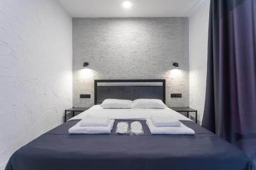 a bedroom with a large bed with two pillows at Hotel West Way in Kutaisi