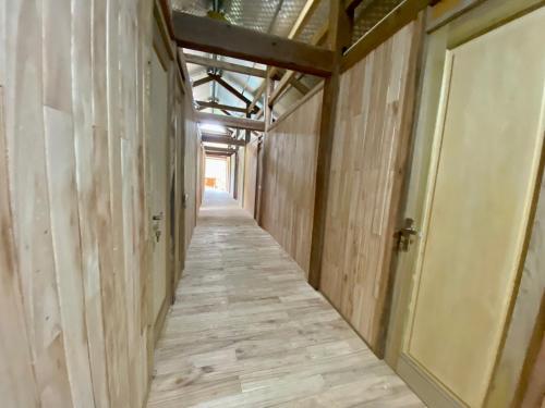 an empty hallway with wood walls and a door at Chipau Homestay Trạm Tấu in Cham Ta Lao