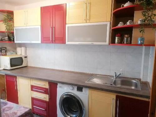 a kitchen with a sink and a washing machine at Casita in Vaslui