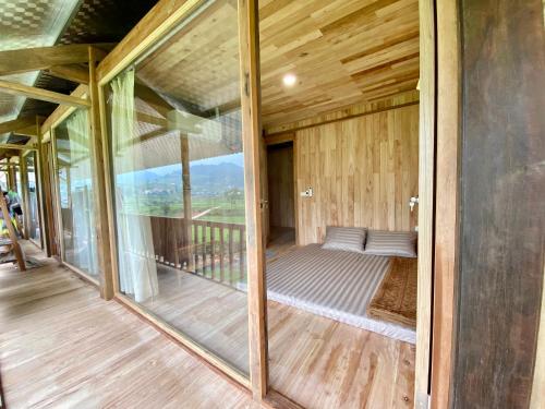 a room with sliding glass doors on a balcony at Chipau Homestay Trạm Tấu in Cham Ta Lao