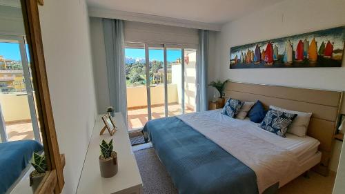 een slaapkamer met een bed en een groot raam bij Sunny holiday Apartment Miraflores in Sitio de Calahonda