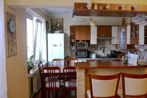 a kitchen with a bar with chairs and a counter top at Apartment Letna near the city center in Košice