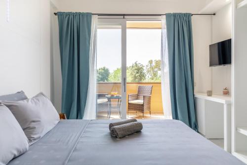 1 dormitorio con 1 cama y vistas a un balcón en crabonaxa suites en Villasimius