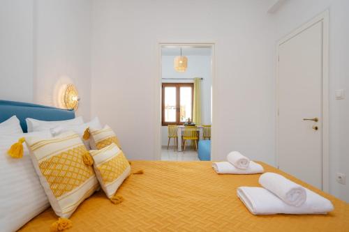 a bedroom with a bed with white and yellow pillows at NaxosAir2 in Naxos Chora