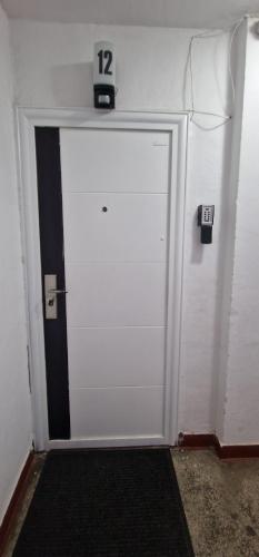 a white door with a clock on top of it at Musura Bay Apartments in Sulina