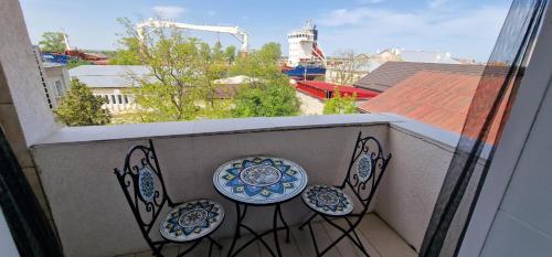 a balcony with two chairs and a view of a city at Musura Bay Apartments in Sulina
