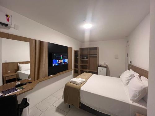 a bedroom with a large bed and a television at Pousada Recanto Forte in Florianópolis