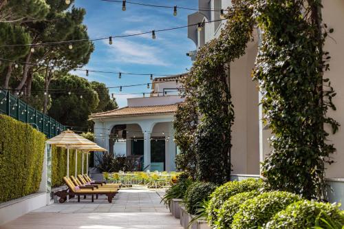 a patio with chairs and tables on a house at The Magnolia Hotel in Quinta do Lago
