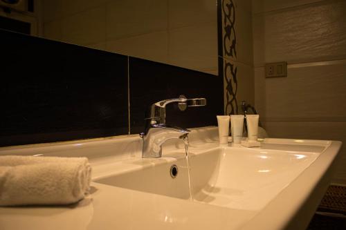 "Chez Riche" Luxury serviced apartment 12 في القاهرة: مغسلة الحمام عليها صنبور وفوط