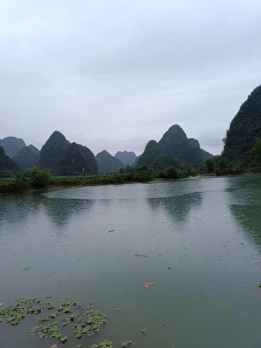 a body of water with mountains in the background at An Homestay - Bar & Motorbike Rental in Cao Bằng