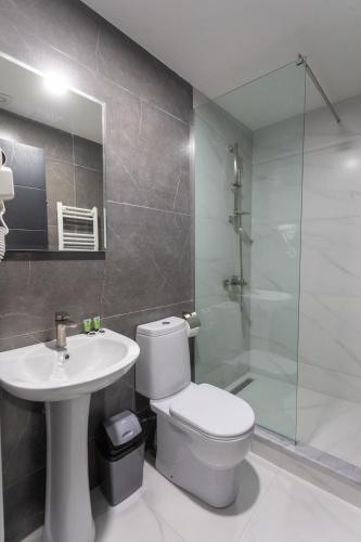 a bathroom with a toilet and a sink and a shower at Hotel West Way in Kutaisi