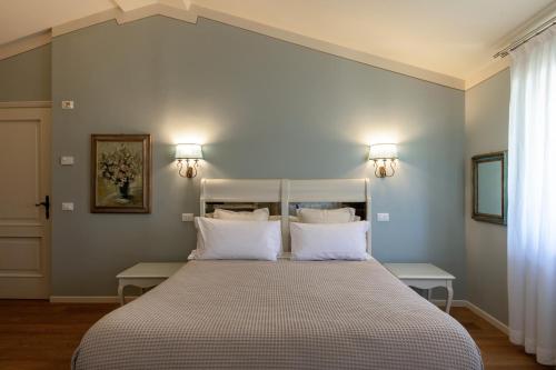 a bedroom with a large bed with white pillows at Relais Borghetto in Valeggio sul Mincio
