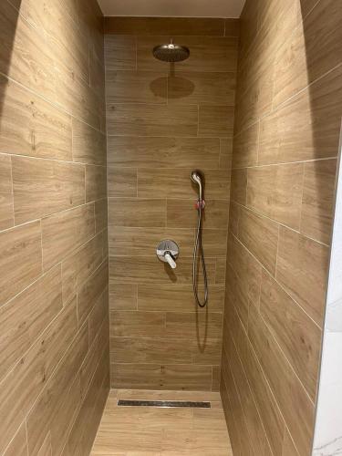 a shower with a shower head on a wall at H&H Rooms Rovinj - Adults Only in Rovinj