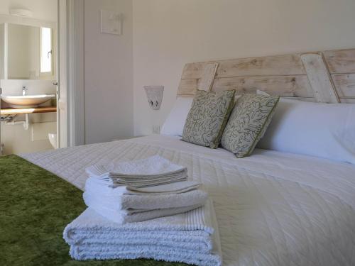 1 dormitorio con 1 cama con toallas en B&B Limone, en San Teodoro