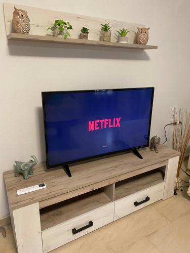 a flat screen tv sitting on top of a wooden entertainment center at Anastasia's House Νιγρίτα near Serres in Nigríta