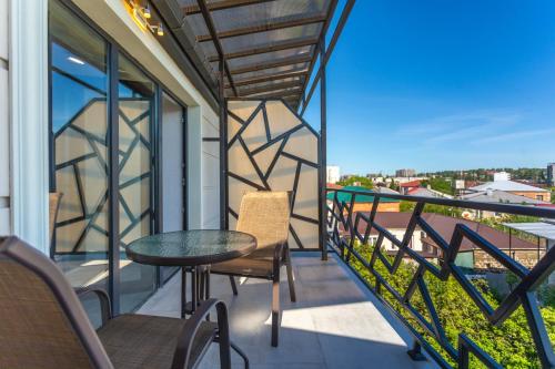 a balcony with a table and chairs and a view at Hotel West Way in Kutaisi