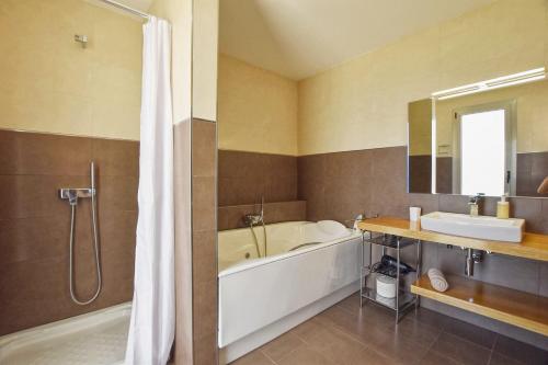 uma casa de banho com uma banheira, um lavatório e um chuveiro em Caleu em Binissalem