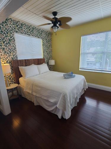 a bedroom with a bed and a ceiling fan at Duval Street Suite overlooking Duval with parking and pool in Key West