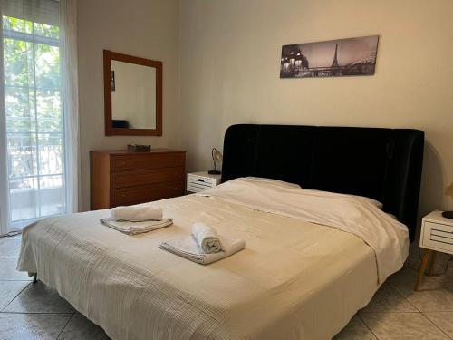 a bedroom with a large bed with towels on it at Fully Furnished Cozy Stay in Thermi