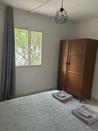 a bedroom with a bed and a dresser and a window at Avra House in Limassol