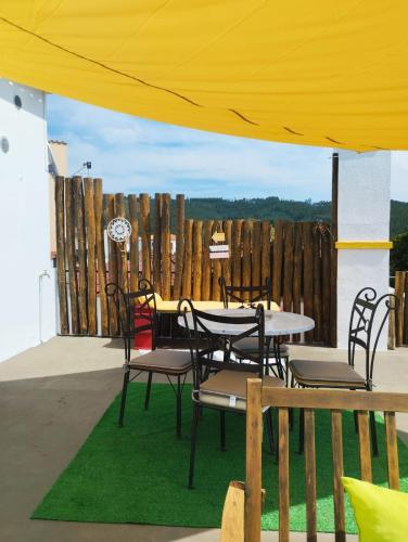 a table and chairs sitting under a yellow tent at Casa Xara in Proença-a-Nova